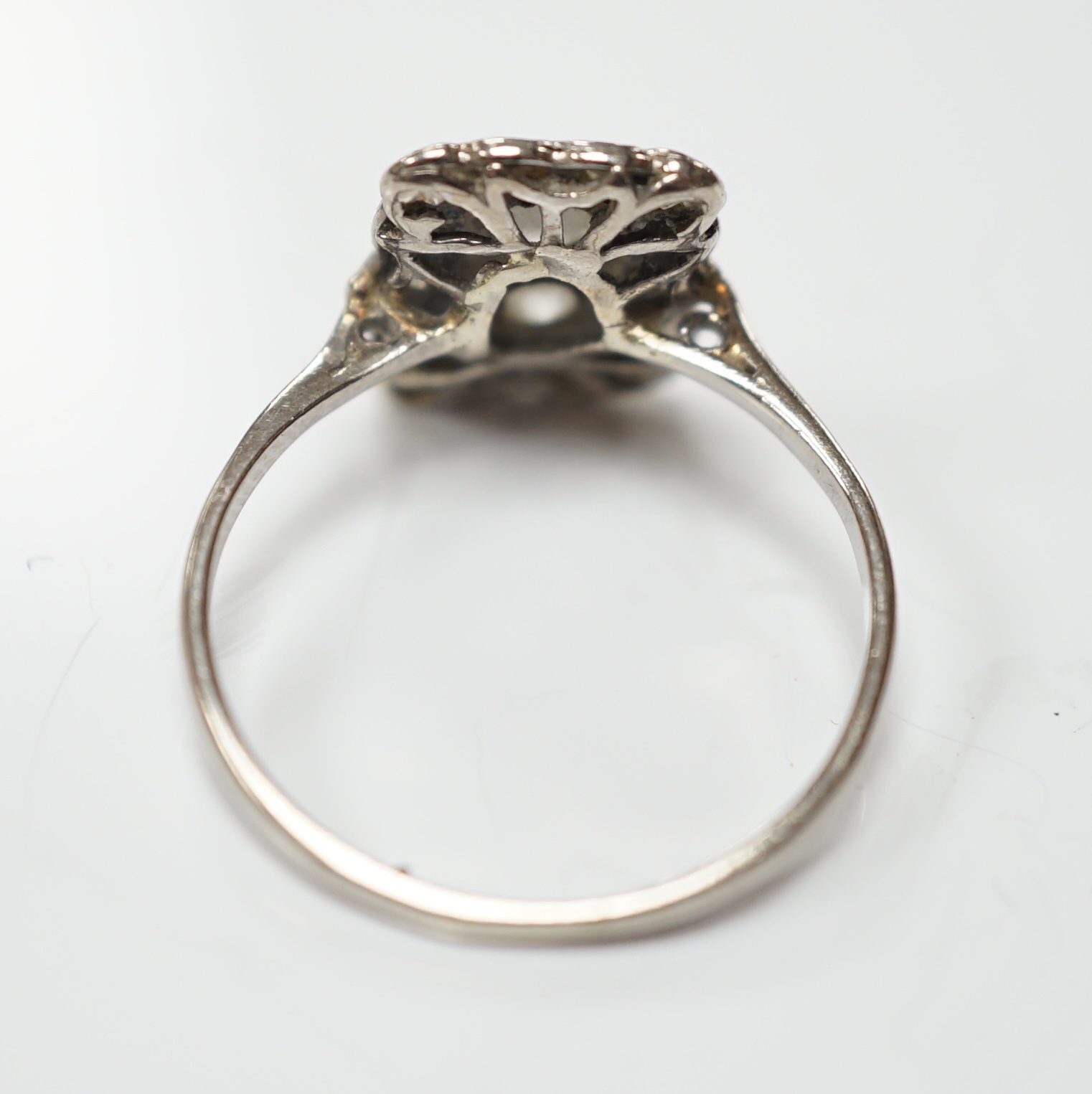 An early 20th century white metal and diamond cluster set tablet ring, size P/Q, gross weight 2.2 grams.